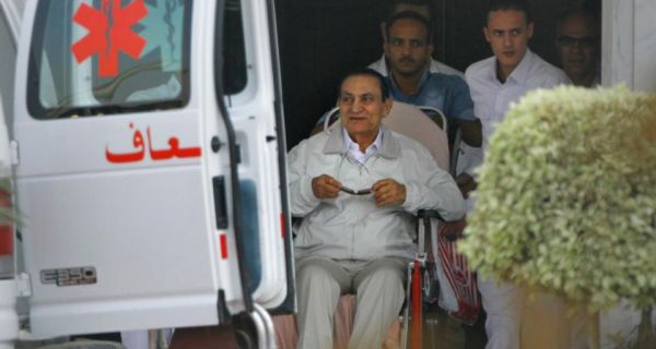 Former Egyptian President Hosni Mubarak, 85, is escorted by medical and security personnel into an ambulance to be taken by helicopter ambulance from Maadi Military Hospital to the Cairo Police Academy - turned - court in Cairo today.