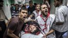 Palestinians carry a man injured in a UN shelter in Gaza yesterday. Witnesses in the shelter said Israeli tanks fired four shells at the building. Photograph: Oliver Weiken/EPA