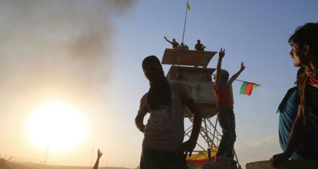 Kurdish protesters gesture as they occupy a post for Turkish border guards yesterday during a protest demanding that the Turkish government do more to help Kobani, in the northeast Syrian Kurdish city of Qamishli bordering the Turkish town of Nusaybin.  Photograph: Dyar Hasso/Reuters