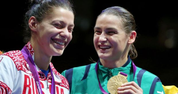 Olympic gold medalist Katie Taylor shares a smile with rival Sofya Ochigava at the London Games - image