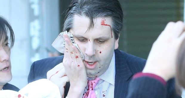 US ambassador to South Korea Mark Lippert covers a wound to his face as he leaves the Sejong Cultural Institute after he was injured in an attack by an ... - image