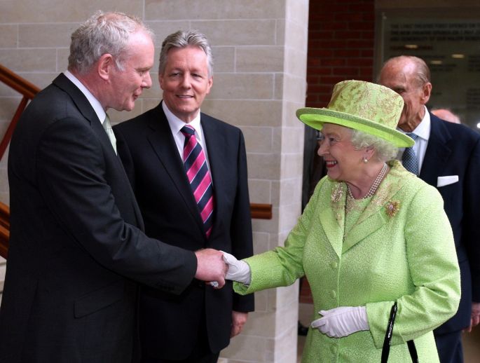 Queen Elizabeth II shakes hands with Northern Ireland Deputy First Minister Martin McGuinnesswatched by First minister Peter Robinson (centre) at the Lyric Theatre in Belfast. Photograph: PA 