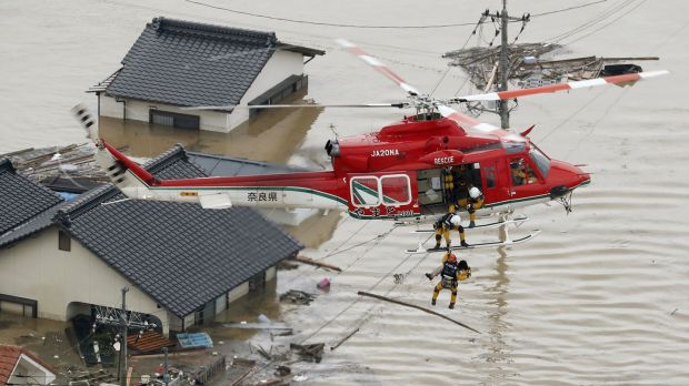   An aerial view shows a local resident rescued from a house submerged by helicopter rescuers in a flooded area of ​​Kurashiki, in southern Japan. Photo: Kyodo / via Reuters 