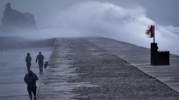Walkers on Howth Harbor during strong winds and rain Tuesday before storm Diana. Photography: Colin Keegan / Collins Dublin.