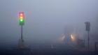 Traffic lights and traffic amid  thick fog in London this morning. Flights have been disrupted at London City airport and Heathrow, the Woolwich ferry was cancelled and low visibility has caused slow traffic on motorways in England. Photograph: Russell Boyce/Reuters