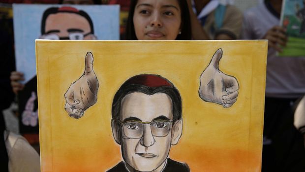 A youth holds a portrait of Archbishop Oscar Romero after the Vatican’s announcement that he will be canonised. The archbishop was assassinated in El Salvador in 1980. Photograph: Rodrigo Sura/EPA