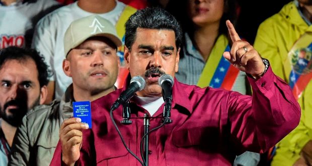 Venezuelan president: Nicolás Maduro holds his country’s political constitution after his re-election was announced in Caracas. Photograph: Juan Barreto/AFP/Getty