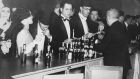 November 1931: Evening dressed drinkers buying at a US bar during prohibition. Photograph: Keystone/Getty Images
