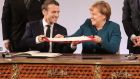 French president Emmanuel Macron and German chancellor Angela Merkel exchange the French-German friendship treaty during the signing ceremony  in Aachen, Germany, on Tuesday. Photograph: Ludovic Marin/AFP/Getty Images