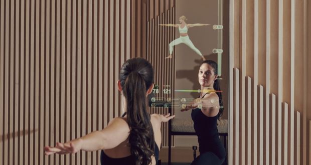 Kailee Combs, the vice-president of fitness at Mirror, works out with some of the demos on one of the Mirror products in their showroom in New York. Photograph: Vincent Tullo/The New York Times