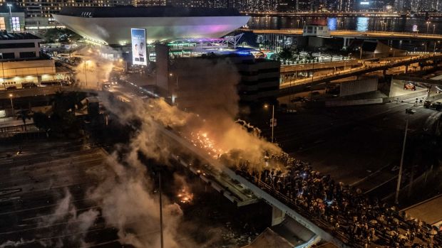 Protesters and police clash on a bridge at The Hong Kong Poytechnic University in Hong Kong. Photograph: Anthony Kwan/Getty Images.