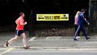 People are seen jogging past a social distancing sign in the Phoenix Park in Dublin last week. Photograph: Jason Cairnduff/Reuters 