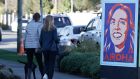 Pedestrians walk past a billboard featuring New Zealand prime minister Jacinda Ardern  in Christchurch, New Zealand. Photograph: Mark Baker/AP