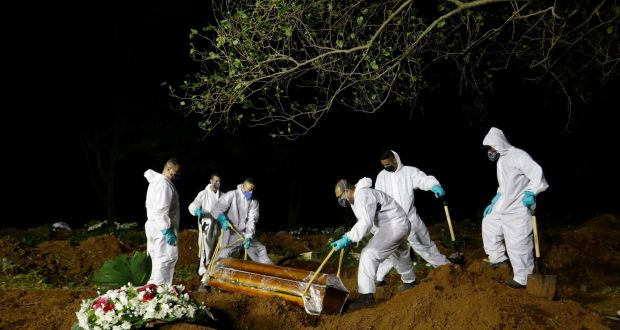 Працівники кладовища опускають труну жертви Covid-19 до його могили на кладовищі Віла Формоза в Сан-Паулу, Бразилія.  Фотографія: Нельсон Антуан / AP Photo