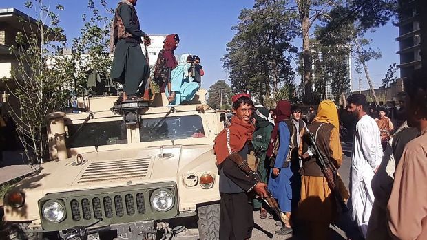 Taliban fighters stand guard along the roadside in Herat, Afghanistanâ€™s third biggest city, on Friday, after government forces pulled out the day before. Photograph: AFP via Getty Images