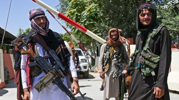 Taliban fighters stand guard along a roadside near the Zanbaq Square in Kabul on Monday. Photograph: Wakil Kohsar/AFP via Getty Images