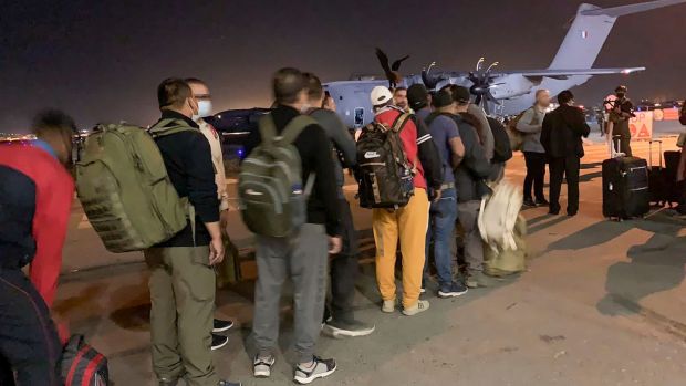 French nationals and their Afghan colleagues line up to board a French military transport plane at Kabul airport. Photograph: AFP via Getty Images