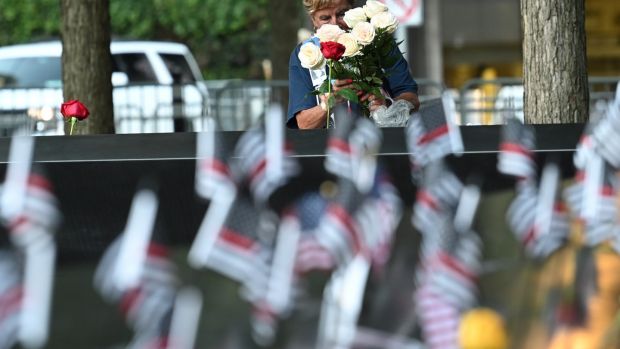 A woman places flowers at the South Tower before ceremonies marking the 20th anniversary of the 9/11 attack at the World Trade Center in New York which killed almost 3,000 people. Photograph: David Handschuh / EPA