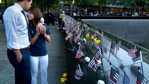 Katie Mascali is comforted by her fiance Andre Jabban as they stand near the name of her father, Joseph Mascali, during 9/11 commemoration ceremonies in New York. Photograph: Craig Ruttle/Pool/AFP/Getty