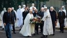 Imams from the Grand Mosque of Paris carry a floral tribute, in front of the school where teacher Samuel Paty worked, in Conflans Sainte Honorine, on Friday. Photograph: Lewis Joly/AP Photo