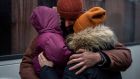 A Ukrainian man kisses his wife and daughter goodbye as they prepare to board a bus to Poland  in Lviv, western Ukraine. Photograph: AP Photo/Bernat Armangue