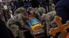 The coffin of senior police sergeant Roman Rushchyshyn, who was killed in the Luhansk region, is lowered during his funeral in the village of Soposhyn, in the outskirts of Lviv, western Ukraine on Thursday. Photograph: Bernat Armangue/AP