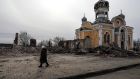 A woman passes near a Moscow Orthodox church that was partially destroyed after being bombed by Russian aircraft, in Malyn, Ukraine. Photograph: Miguel A Lopes/EPA