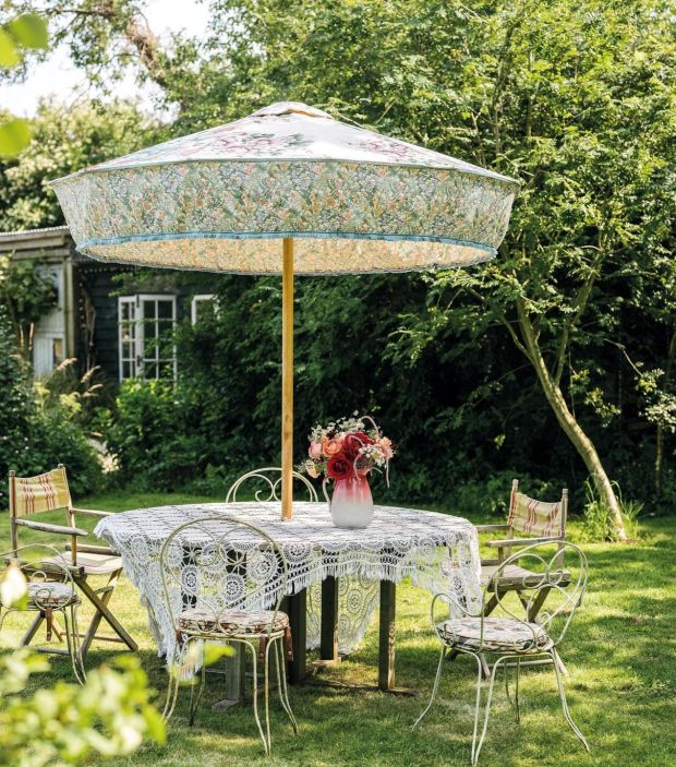 Pearl Lowe's garden with a Sunbeam Jackie parasol and a lace scarf strewn across the table.  Photography: Dave Watts