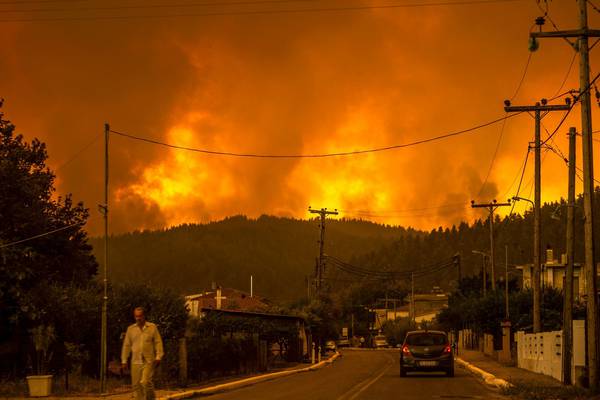 Thousands flee Greek island as wildfires raze forest and homes