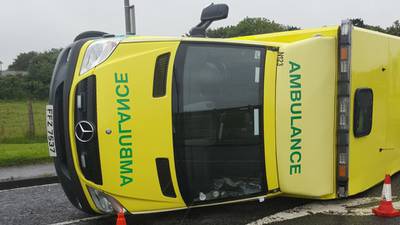 Ambulance flipped on its side in road collision