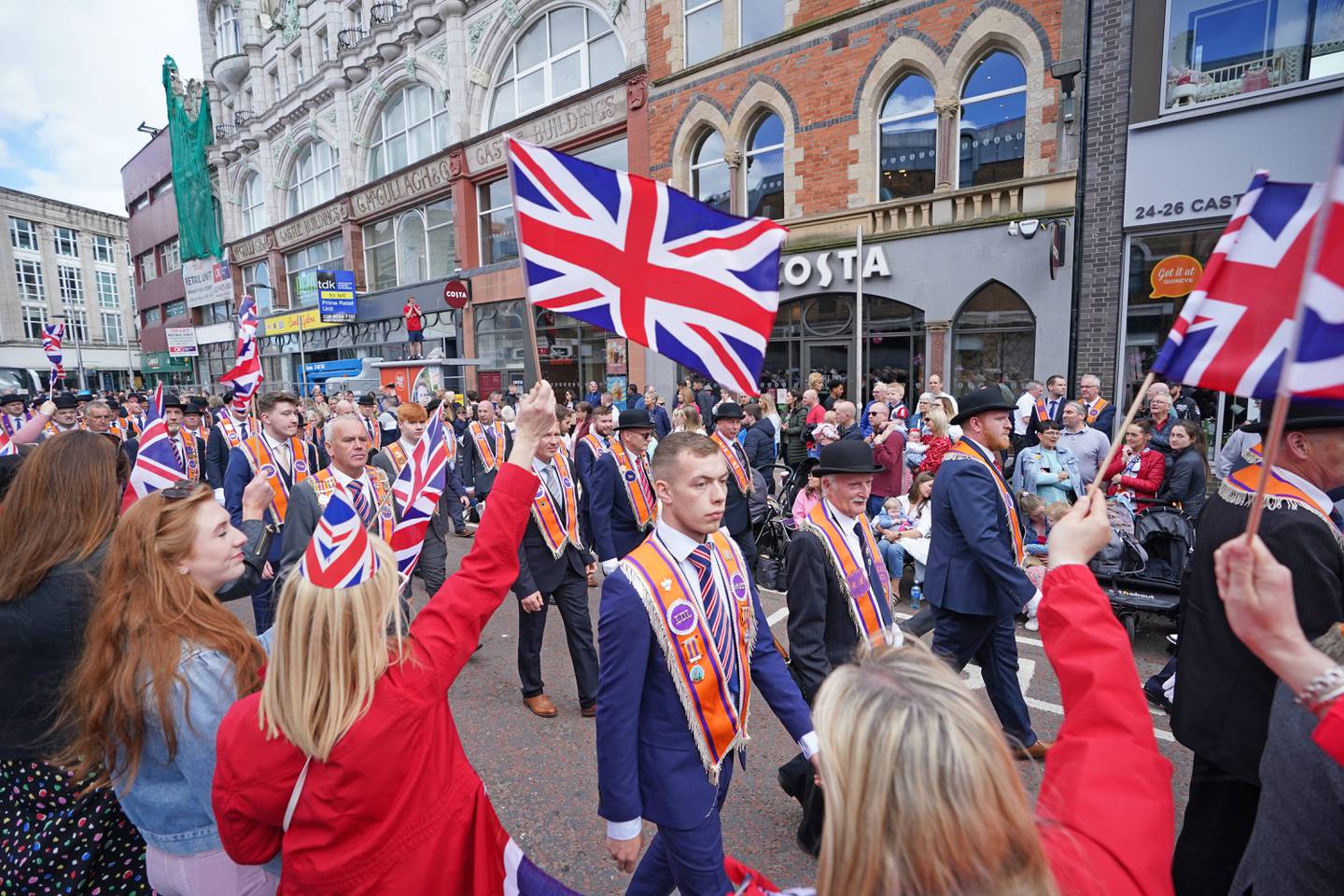 Tens of thousands of Orange Order members parade in Belfast to mark NI