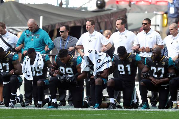 Donald Trump defied as scores of NFL players kneel for anthem