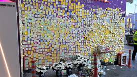 People place flowers at memorial wall in Seoul on anniversary of Halloween stampede 