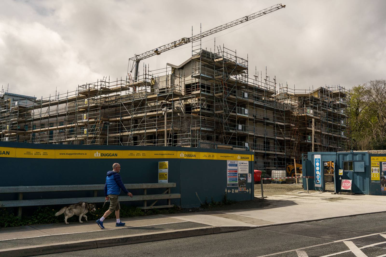A pedestrian passes a residential construction site in the Sandyford district of Dublin, Ireland, on Monday, May 10, 2021. The mass purchase of affordable houses  on the market for about 400,000 euros ($490,000)  set off a public firestorm and highlights the growing tension over the squeeze in urban housing and the role of large investors. Photographer: Paulo Nunes dos Santos/Bloomberg