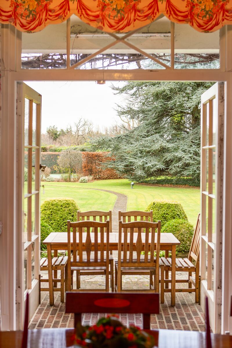 The three reception rooms at the back are connected from the outside and the inside, opening through original glass doors to the brick-patioed porch. 