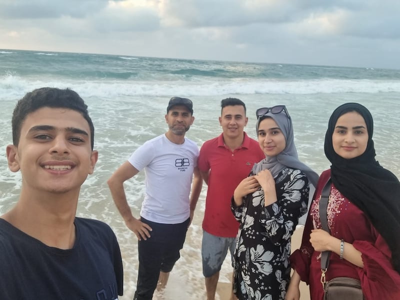 Dr Mahmoud Abumarzouq (in white t-shirt) standing with his niece Noor (to his extreme left) and Dinna, next to her. His nieces were killed in an Israeli airstrike on Gaza on Monday.