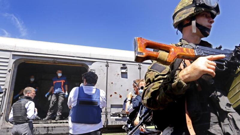 Separatist armed soldiers guard the scene while forensic experts from Netherlands (centre background) check the body-bags lying on the floor inside one of the train’s refrigerated coaches that preserves the bodies of the victims of Boeing 777 Malaysia Airlines flight MH17. Photograph: Robert Ghement/EPA