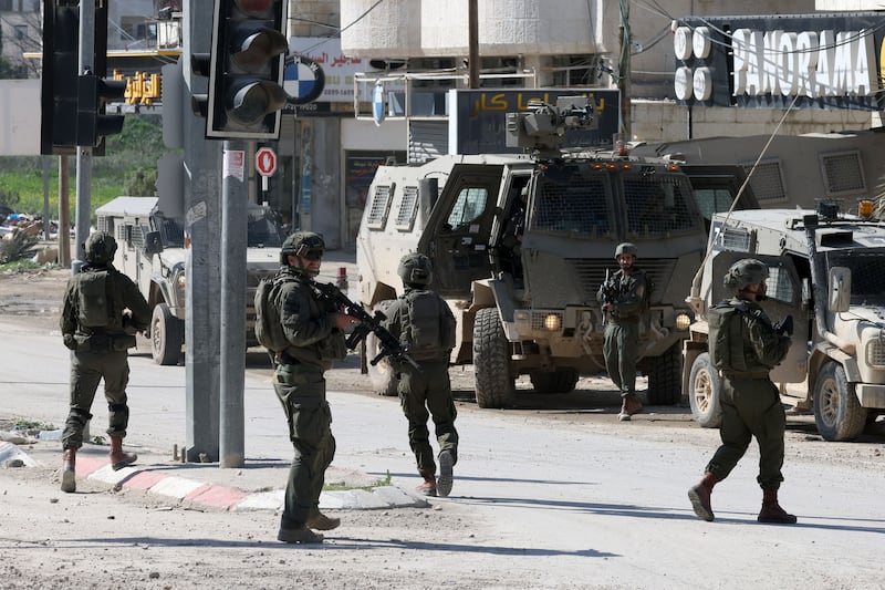 Israeli soldiers patrol near army vehicles in the West Bank city of Jenin. Photograph: Alaa Badarneh/EPA