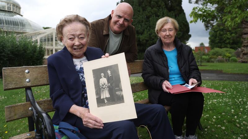 Conor Pope with his aunts Betty Kearns (left) and Ann Little (right) in the Botanic Gardens. Betty is holding a photo from the wedding day in June 1930 of Conor’s grandad (her father) Arthur Pope who married Greta Mary Clare. Photograph: Bryan O’Brien