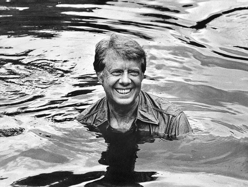 Jimmy Carter, the Democratic front runner for the presidential nomination, in a pond as he and friends drain a pond and catch fish for a fry the next day in Plains in his hometown of Plains in June 1976. Photograph: George Tames/The New York Times
                      