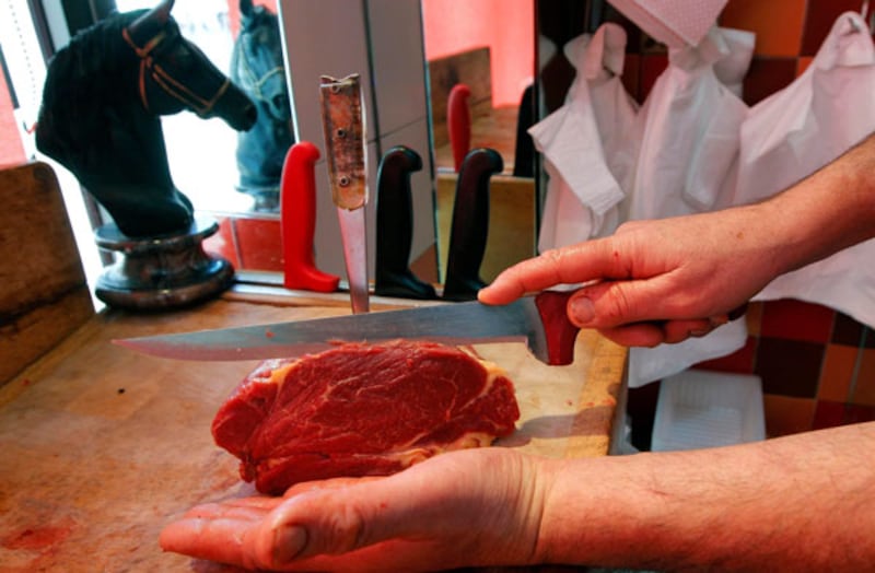 A French butcher cuts a piece of horse meat on a block in a horse butchery shop in Marseille. Photograph: Jean-Paul Pelissier/Reuters