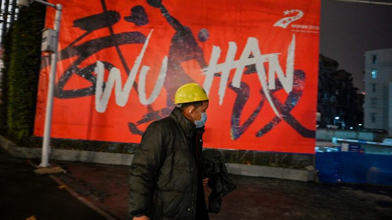 A man wearing a protective face mask walks along a street in Wuhan, China, on Sunday. The city is at the epicentre of a coronavirus outbreak that has killed at least 56 people. Photograph: Hector Retamal/AFP/Getty