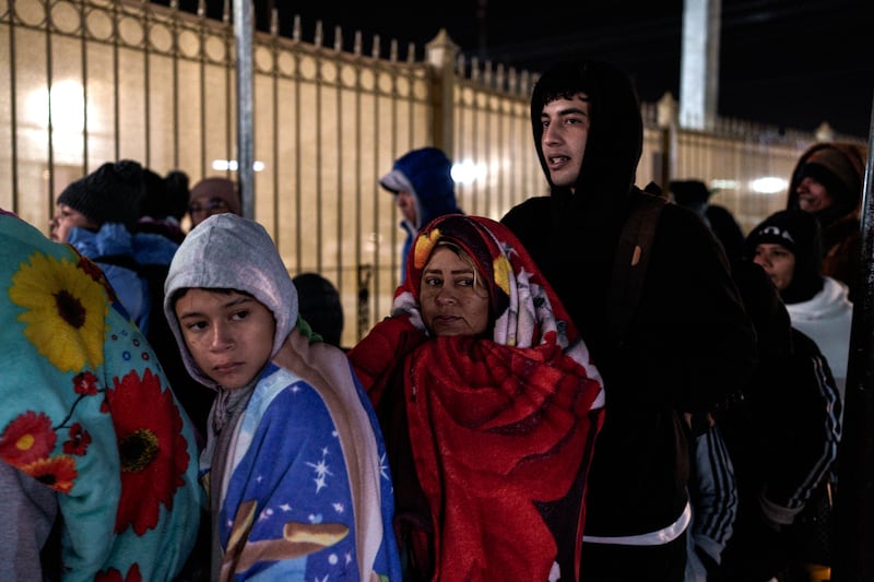 Inez Alarcón (35), her son William Josué Torres Alarcón (16), and a family friend, Anderson Mora (18), all from Venezuela wait in line for their appointments with US immigration authorities at the Paso Del Norte International Bridge between the US and Mexico on Donald Trump’s Inauguration Day on Monday. Photograph: Paul Ratje/The New York Times
                      