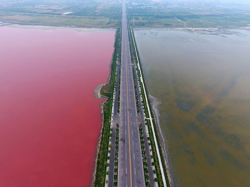 Red and green salt water either side of a  road crossing a salt lake  in Yuncheng, Shanxi Province of China. Photograph: Visual China Group via Getty