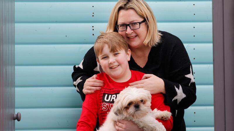 Maxine Walsh, with her son Noah (holding their dog Bluebell) at their home in Tallaght. Maxine faced difficulties in  getting her son a Covid-19 vaccine. Noah managed to get a vaccine on Wednesday. Photograph: Alan Betson