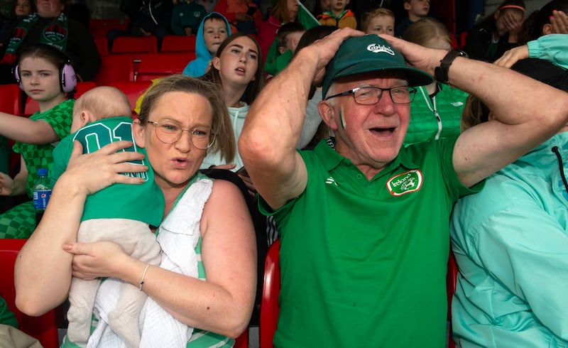 Aoife Elders with baby James and her father Robert Elders watching the Ireland-Canada World Cup game on the big screen in Turners Cross in Cork. Photograph: Michael Mac Sweeney/Provision