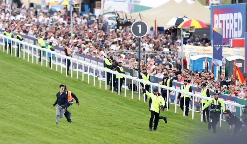 A protester runs onto the race track but is arrested as he fails to disrupt The Betfred Derby during Derby Day at Epsom Downs. Photograph: Warren Little/Getty Images