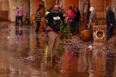 A man reacts in front of houses affected by floods in Utiel, Spain (Manu Fernandez/AP)