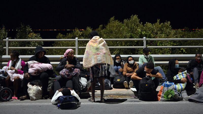 Asylum seekers sit on the pavement outside the Moria refugee camp after a fire. Photograph:  Stratis Balaskas/EPA