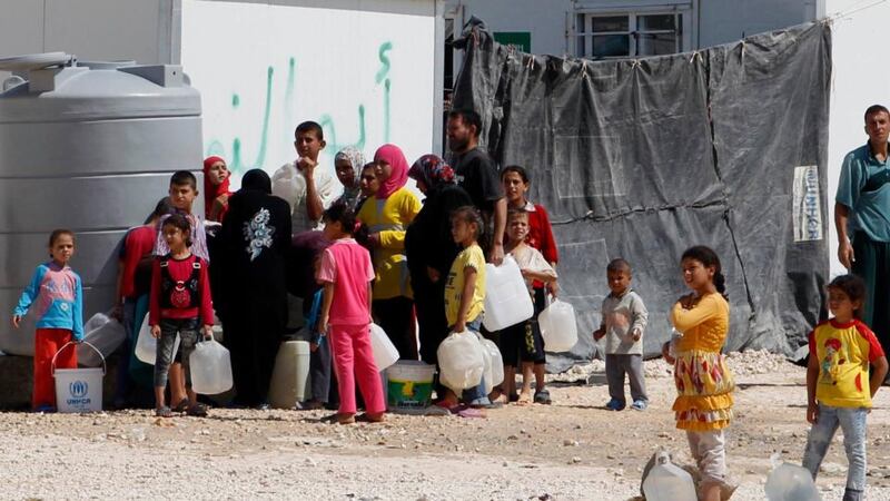 Syrian refugees wait to collect water at the Al Zaatri refugee camp in the Jordanian city of Mafraq, near the border with Syria yesterday. Photograph: Muhammad Hamed/Reuters